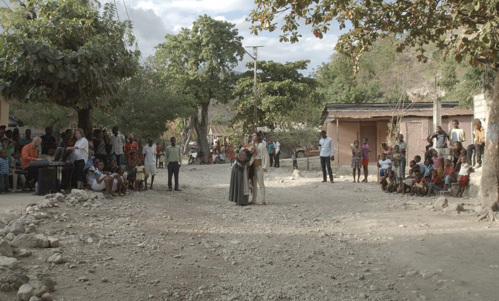 C.T. Jasper & Joanna Malinowska Halka/Haiti. 18°48’05”N 72°23’01”W, 2015 Soloists from the Poznan Opera House, musicians from Holy Trinity Philharmonic Orchestra of Port-au-Prince, and dancers and audience from Cazale during the performance. Cazale, Haiti, February 7, 2015.   Courtesy of the artists and Zachęta – National Gallery of Art.  Still from a multichannel video projection. Cinematography by Barbara Kaja Kaniewska and Mateusz Golis. © C.T. Jasper, Joanna Malinowska. Gift of Joleen and Mitchell R. Julis, 2016 