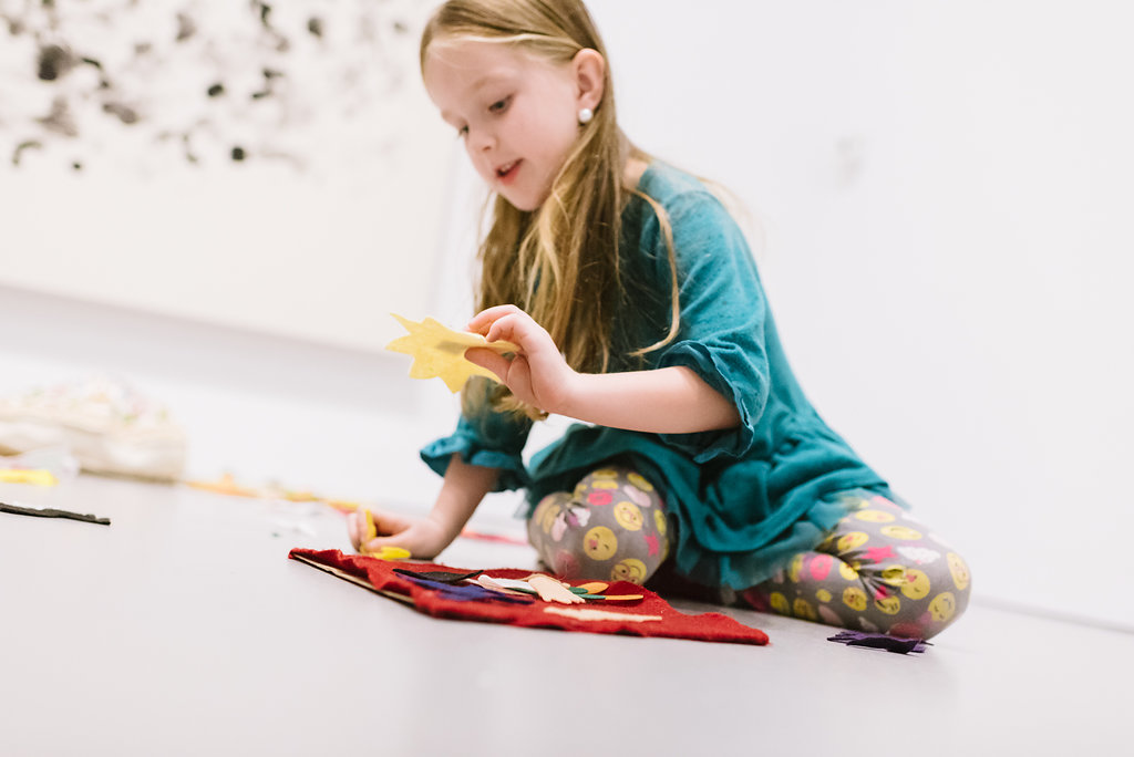 Child playing with LEGOs in gallery