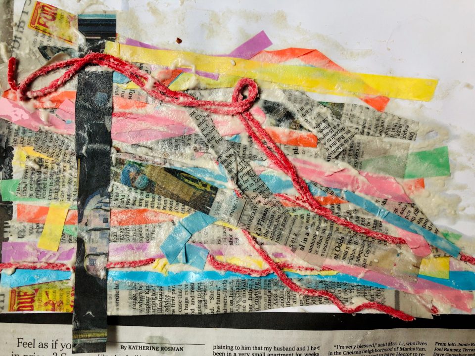 Collage of wet strips of newspaper, colored paper, and red yarn placed diagonally across a canvas with one strip intersecting the rest