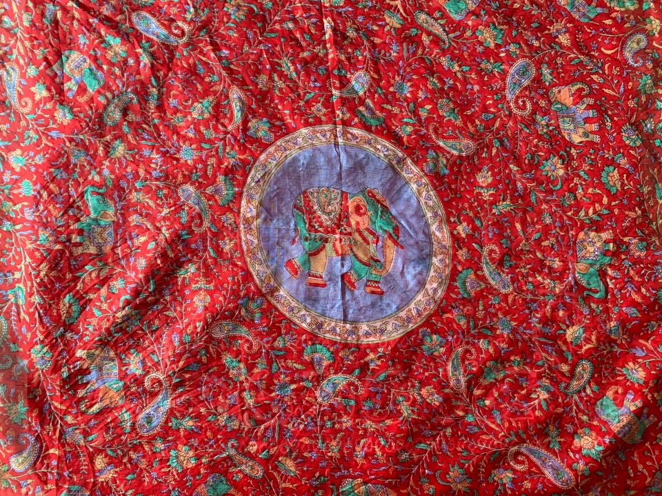 Large, red, paisley patterned scarf, laid flat.