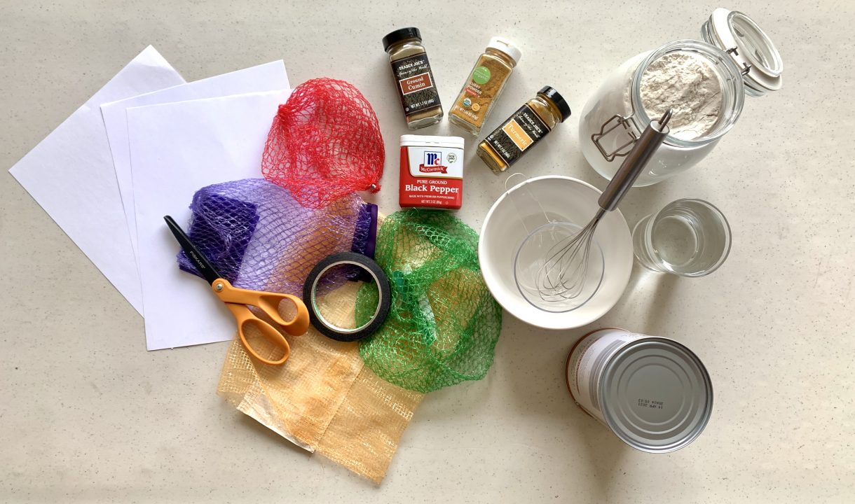 An arrangement of paper, scissors, tape, produce nets, spices, water and flour.