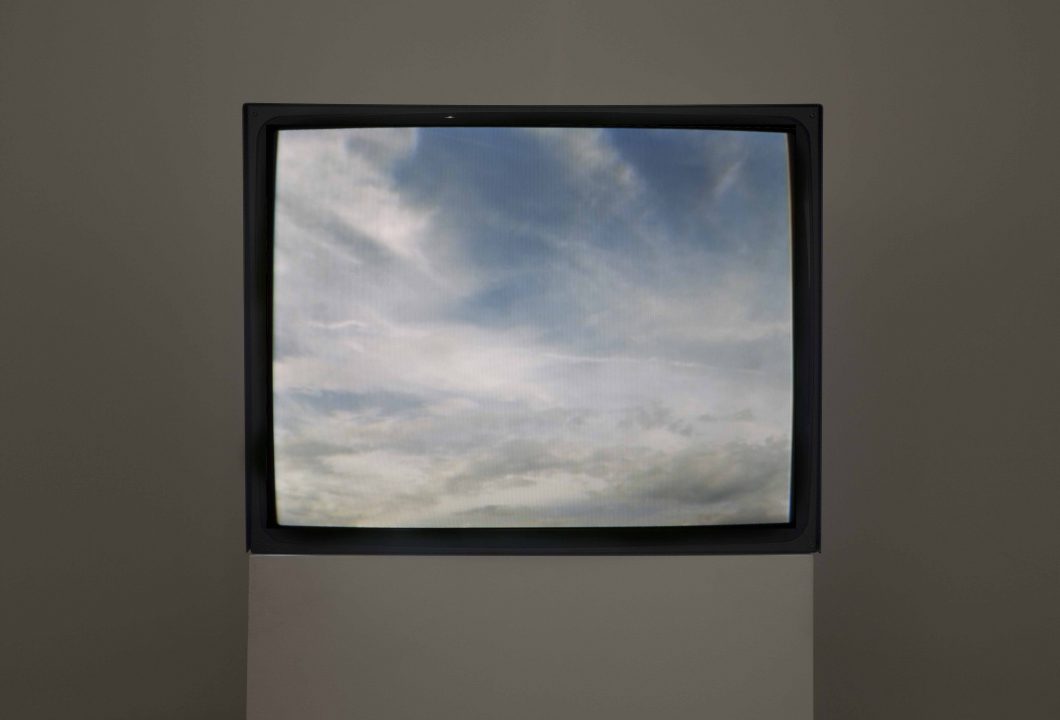 A TV screen on a pedestal shows image of the sky