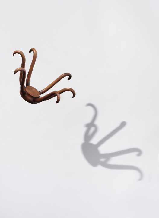 Top portion of hat rack floating against white background with shadow