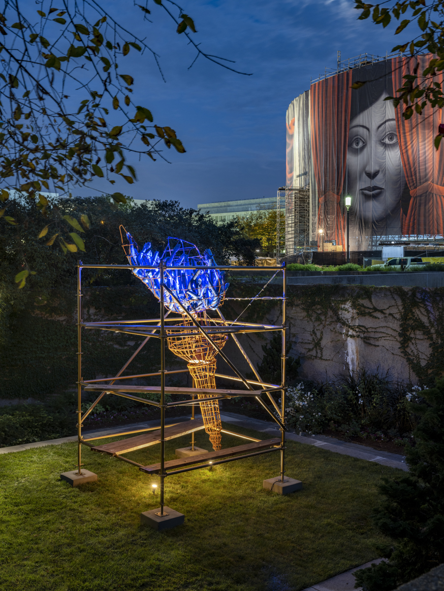 Abigail DeVille's Light of Freedom is dramatically highlighted against a darkening sky in the HIrshhorn Museum's Sculpture Garden.
