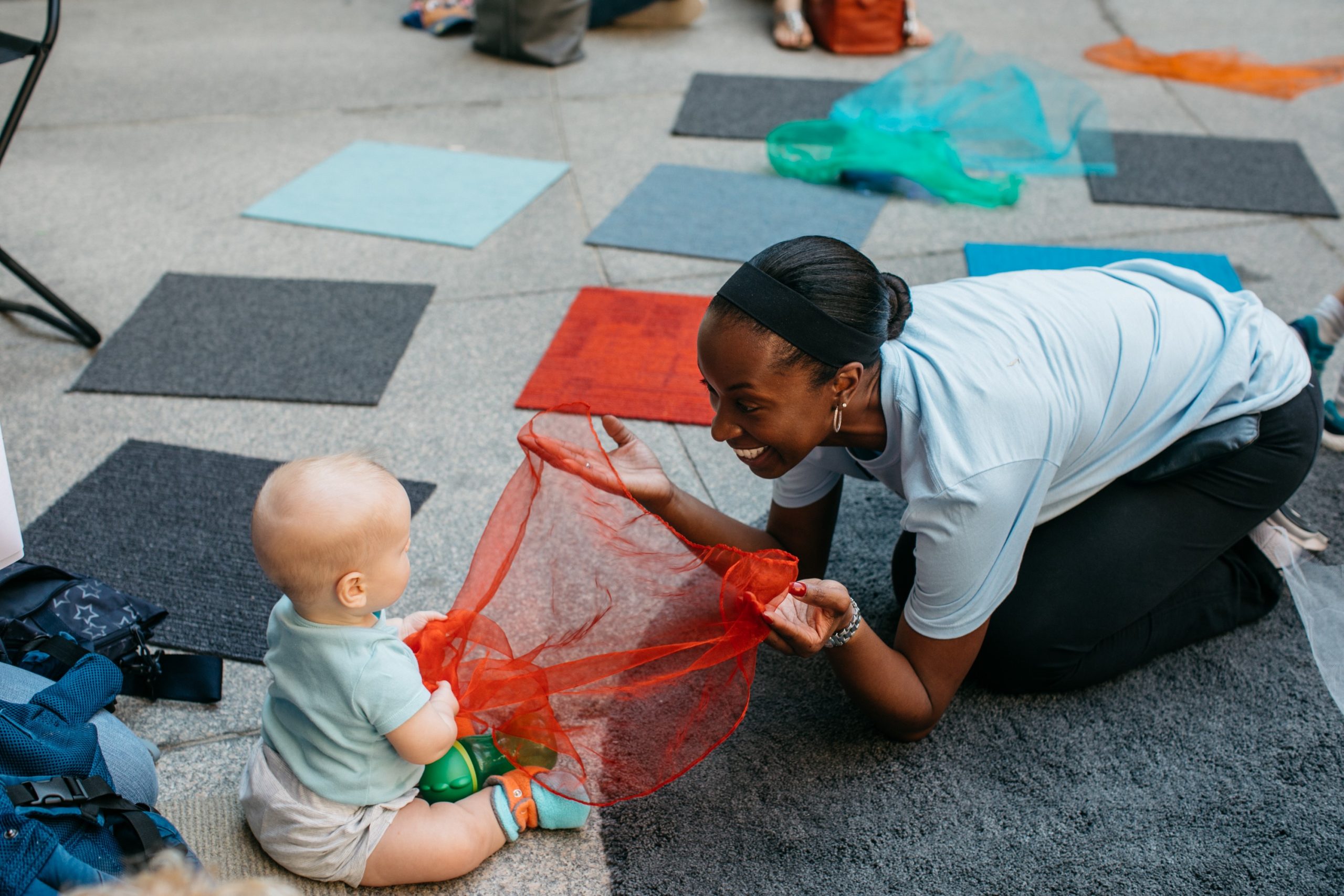 A caregiver and baby interact in the Hirshhorn's plaza.