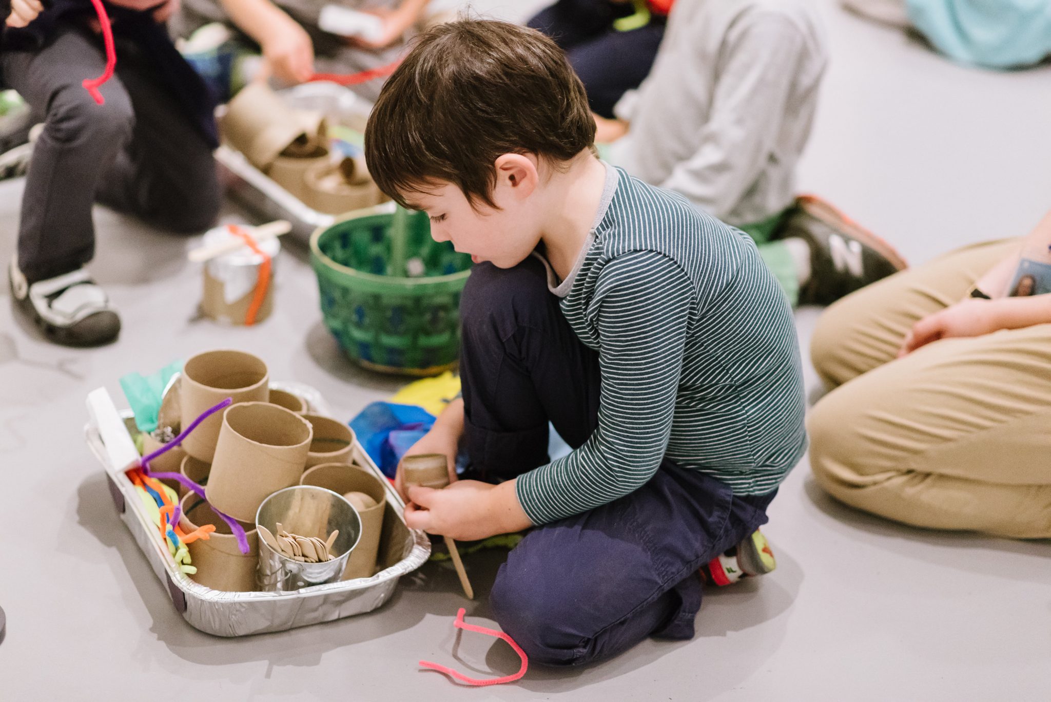 a child gathers supplies from an aluminum foil casserole pan.