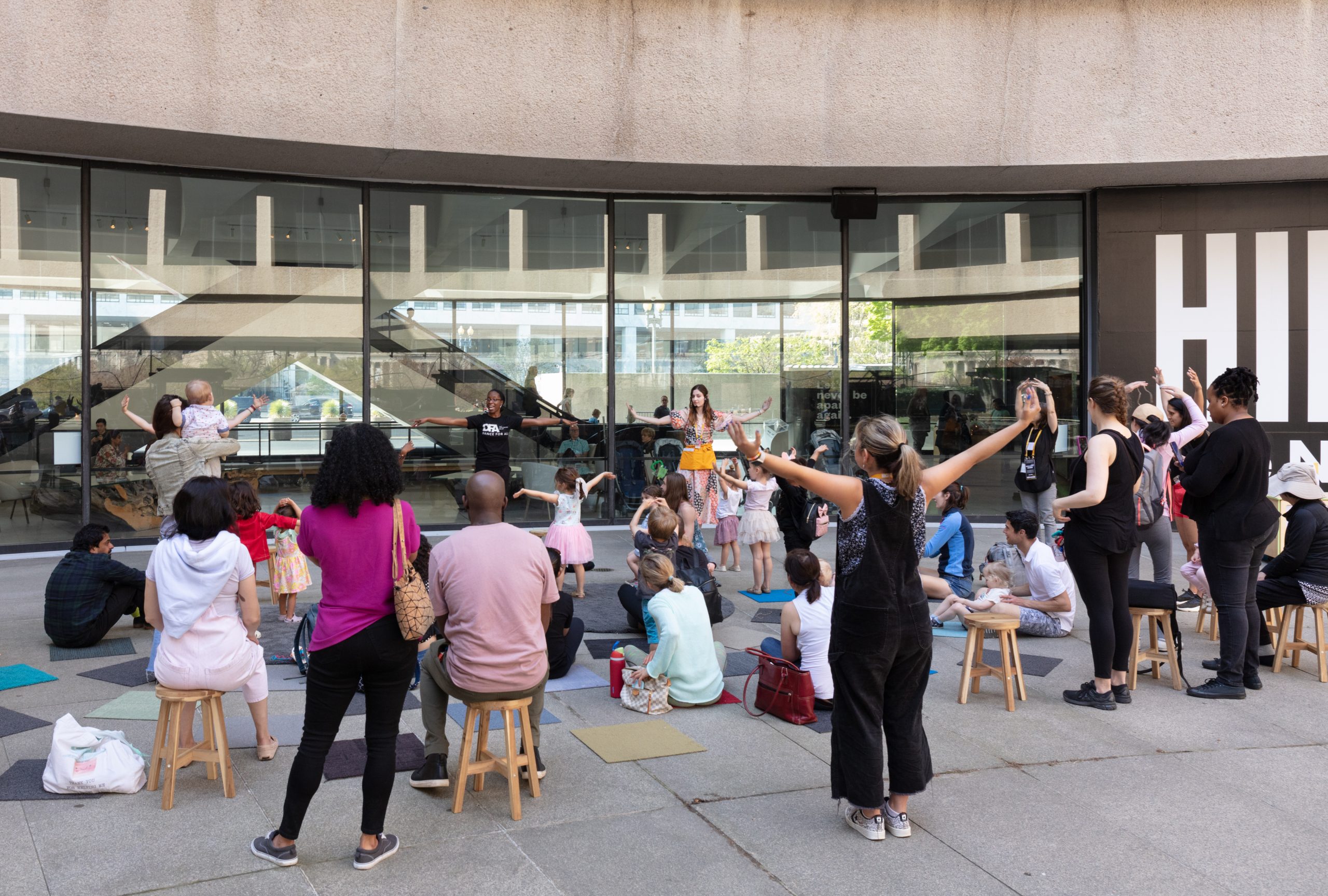 A group of educators, children and caregivers participate in Storytime together on the Hirshhorn's Plaza.