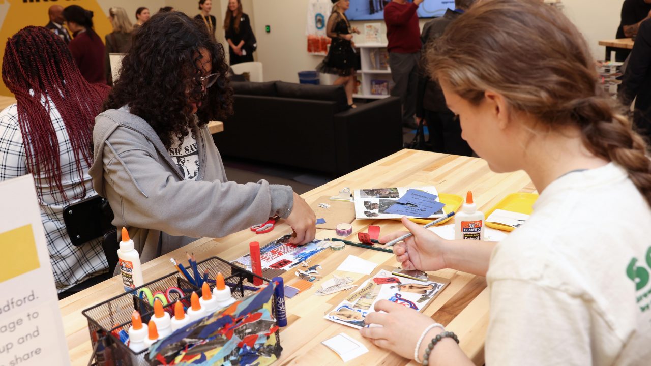 Children sitting at a desk participating in a craft activity