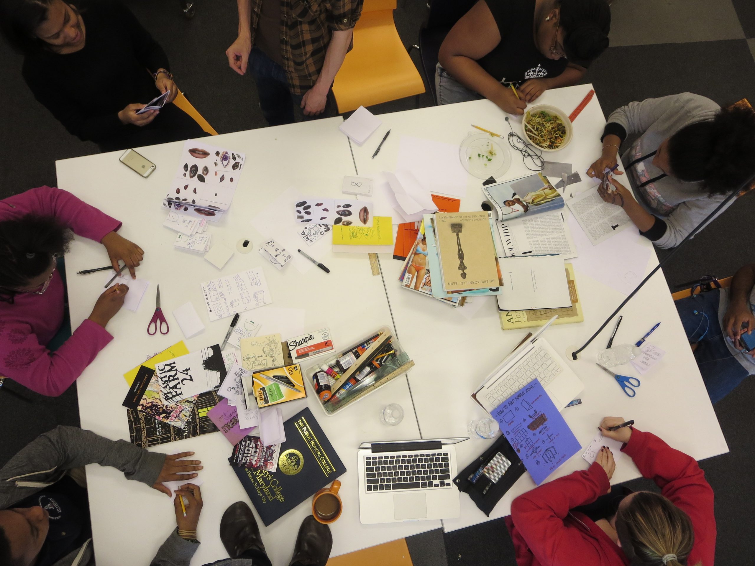 Teens sitting around a table making craft projects