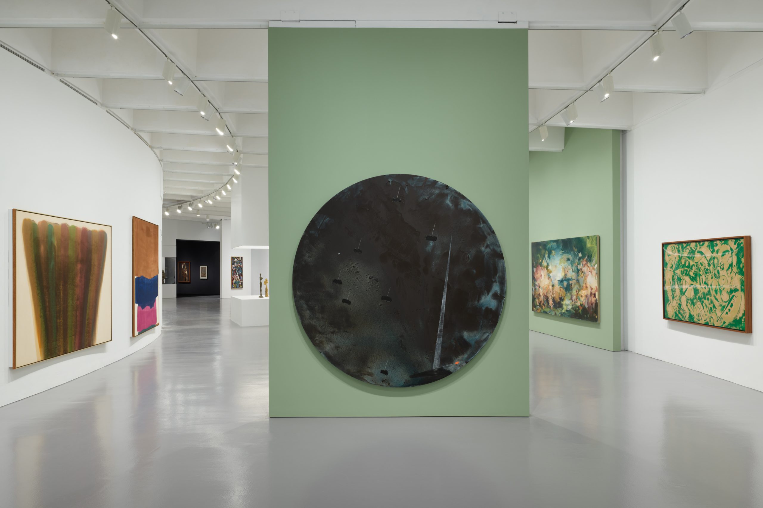 a gallery filled with large abstract paintings in a multitude of dark colors are displayed