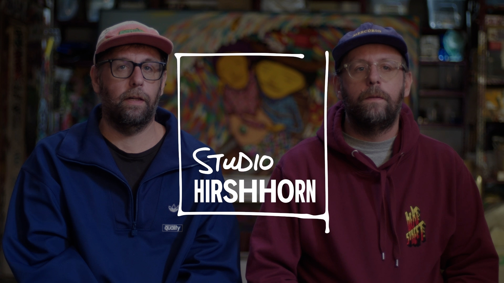 Artist duo OSGEMEOS sitting in their studio. Logo reads Studio Hirshhorn.