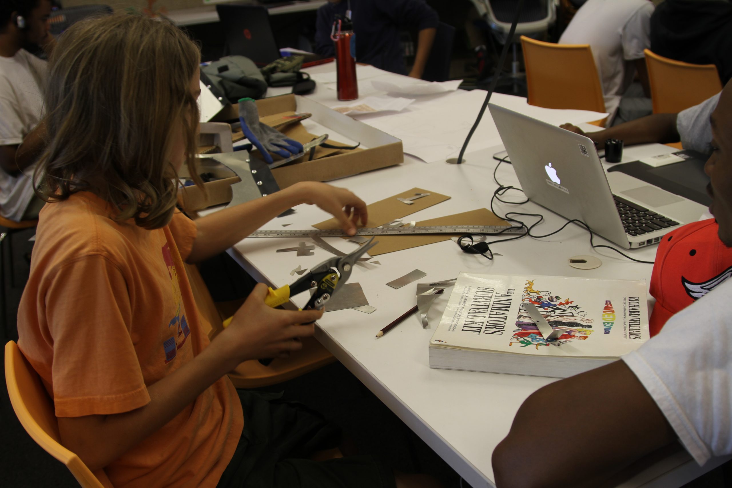 kids making art on a long white table