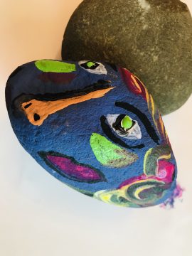 a painted rock with a face