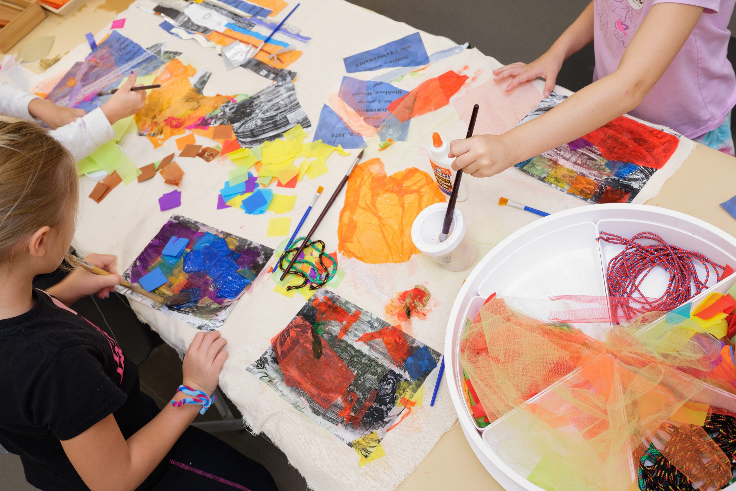 children sitting around a table making craft projects